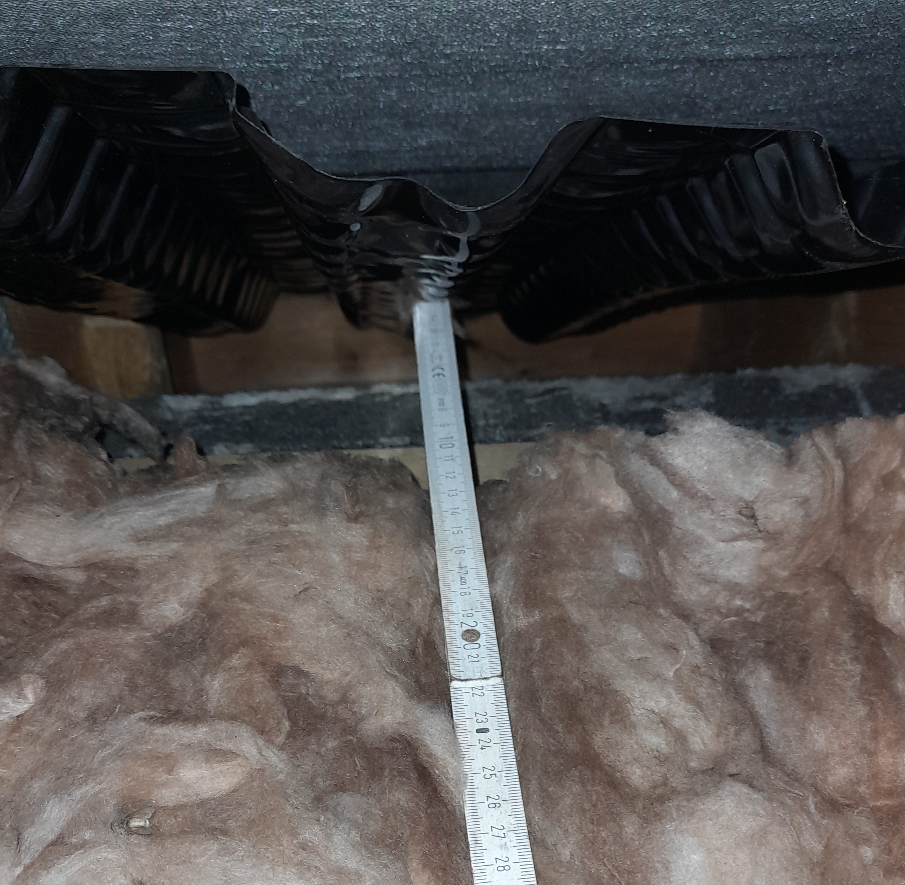 Fig. 3: Bottom layer of insulation at the eaves. Near the top of the image, the black plastic eaves ventilation tray is visible. Below this, in grey, is the inner leaf of blockwork. The insulation should be entirely covering the blockwork, pushed up snug against the eave’s ventilation tray. The blockwork is instead cold, which means water vapour is more likely to condense on it in the room below. Fig. 3: Bottom layer of insulation at the eaves. Near the top of the image, the black plastic eaves ventilation tray is visible. Below this, in grey, is the inner leaf of blockwork. The insulation should be entirely covering the blockwork, pushed up snug against the eave’s ventilation tray. The blockwork is instead cold, which means water vapour is more likely to condense on it in the room below.